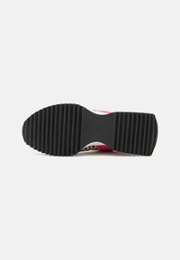 Semelle en caoutchouc noir avec texture striée. Dessus doté d'accents rose, blanc et imprimé léopard. Forme courbée avec un design léger.