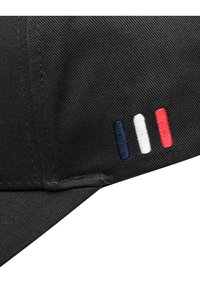 Svart caps med broderte striper i marineblått, hvitt og rødt på siden, med en teksturert overflate og buet skjerm.