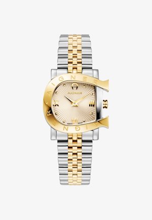 Ura iz nerjavečega jekla v zlati in srebrni barvi s kvadratnim številčnico, teksturirano svetlo zlato številčnico, velikim izbočenim imenom blagovne znamke in rimskimi številkami kot kazalniki.