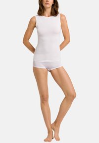 Hvid ærmeløs top lavet af et glat, let stof, parret med hvide boyshorts. Enkel design uden mønstre eller udsmykninger.