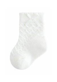 Calcetín blanco hasta el tobillo con un patrón de zigzag texturizado y un pequeño lazo decorativo cerca del puño.