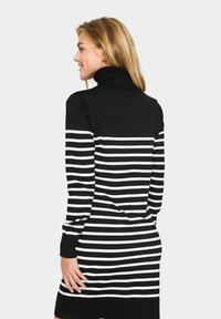 Black and white striped knit dress with a high neck, long sleeves, and a fitted silhouette, featuring horizontal stripes and ribbed cuffs.