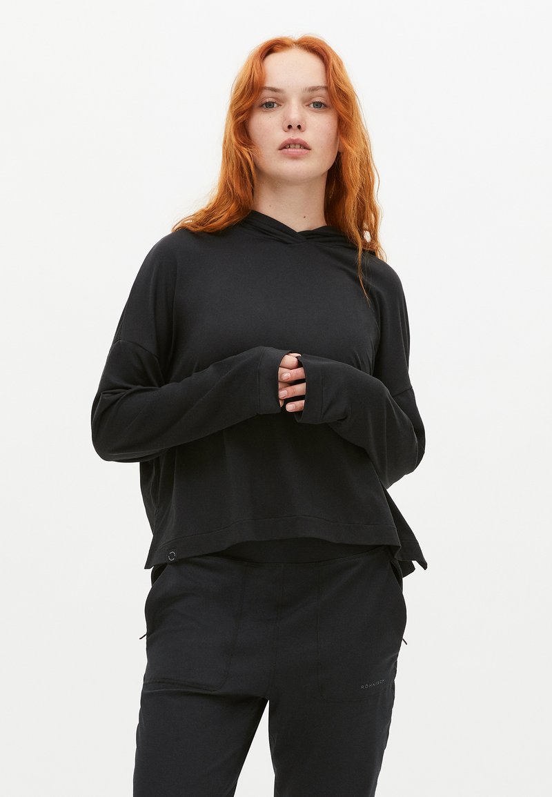 Svart långärmad hoodie med avslappnad passform, huva och hål för tummen. Tillverkad av lätt tyg och har en något längre bakre nederkant.