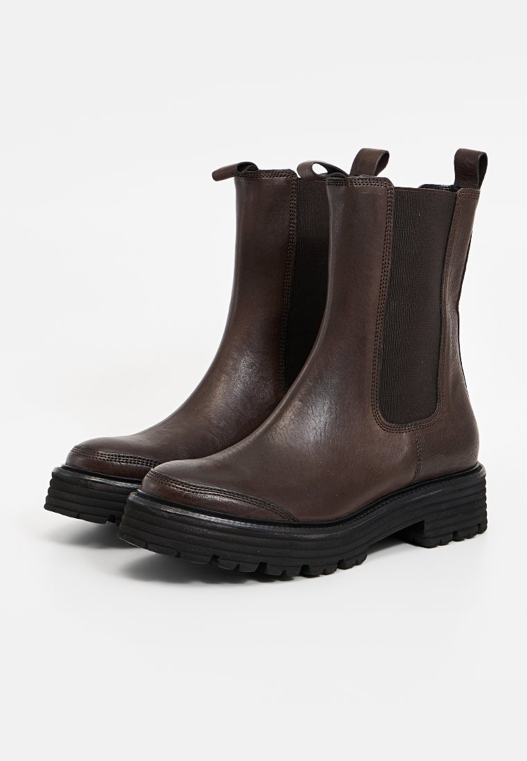 Braune Leder-Ankle-Boots mit elastischen Seitenpartien, strukturierten Akzenten und einer robusten schwarzen Gummisohle. Abgerundete Zehen und Ziehschlaufen für einen einfachen Einstieg.
