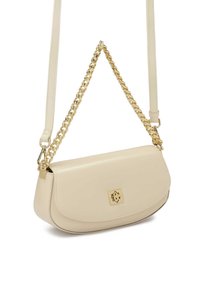 Krémová kožená kabelka přes rameno s zakřiveným tvarem, zlatým řetízkovým popruhem a zlatým logem na přední straně. Hladký povrch, minimalistický design.