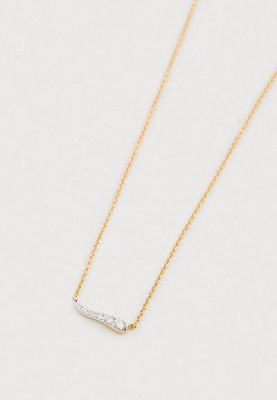 Kuldne kett kaelakee kaarekujulise hõbedase aktsendiga, millel on viis väikest läbipaistvat vääriskivi. Peen disain ja sile pind.