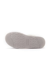 Weiße Schuhsohle mit strukturiertem Grip-Muster. Enthält Branding auf der Zwischensohle und hat eine abgerundete Kante für zusätzlichen Komfort. Hergestellt aus langlebigem Gummi.