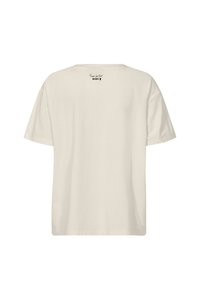 Cream-colored t-shirt featuring a relaxed fit, short sleeves, and a rounded neckline with a printed label on the back near the neckline.