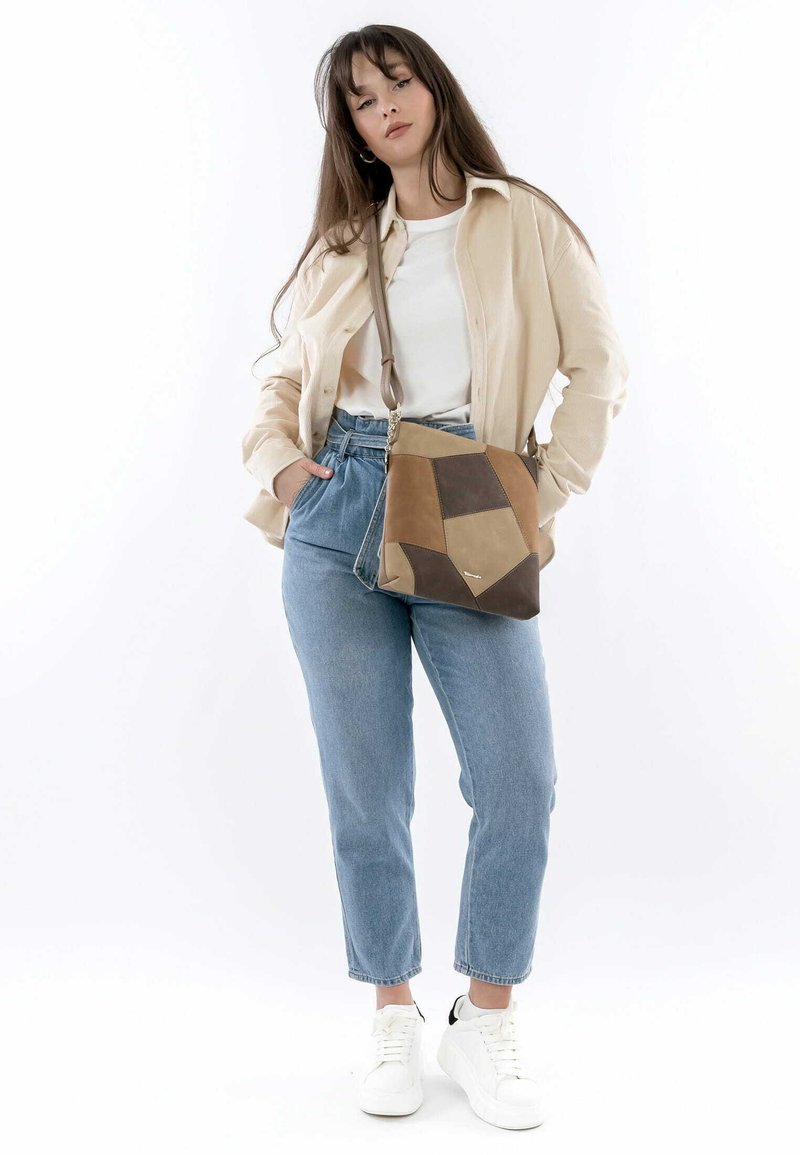 Geometric patchwork handbag in beige, brown, and dark brown leather. Features a detachable strap and textured surface.