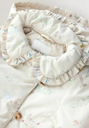 Ljusbeige jacka med volangkrage, prydd med ett blommönster i pastellfärger. Inklusive två knappar för stängning och en varumärkesetikett.