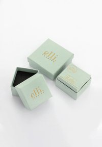 Green, textured paper gift boxes with gold "elli premium" logo; one open revealing a black interior, others closed, varying sizes.