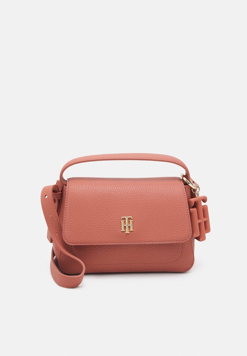 Bolso de mano de cuero de melocotón con acabado texturizado, logo dorado, asa superior y correa de hombro desmontable. Presenta un cierre de solapa seguro.