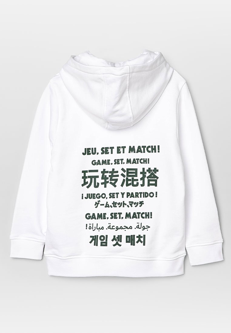 Witte hoodie met meerkleurige tekst in verschillende talen, waarop "Game, Set, Match!" in vette letters staat, gemaakt van een zachte, geweven stof.