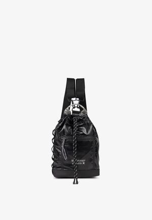 Mochila negra con cordón, bolsillo delantero con cremallera, correas anchas para los hombros y texto reflectante en la parte frontal, mostrada sobre un fondo blanco.