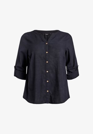 Blusa negra de manga larga con botones de madera en la parte delantera y mangas remangadas aseguradas con pestañas y botones.