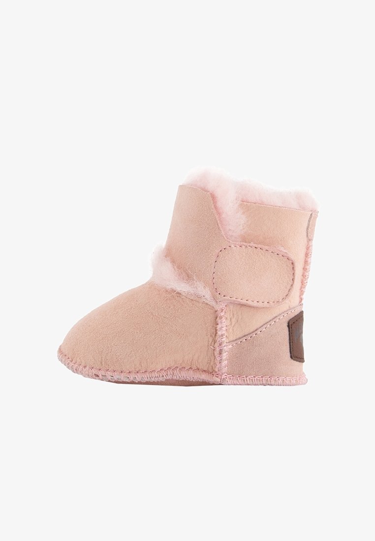 Botte de bébé rose doux avec doublure en peau lainée et une large bande Velcro pour une fermeture facile, présentée sur un fond blanc.