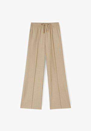Pantalones de pierna ancha beige con una tela texturizada, que presentan una cintura elástica y un cierre de cordón con herrajes dorados.