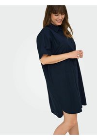 Rochie cămașă de culoare albastru închis, cu un croi lejer, mâneci scurte și tiv curbat. Fabricată dintr-un material neted, fără modele evidente.