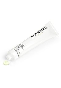Eisenberg Paris Gesichtsmaske in einer weißen, druckbaren Tube mit schwarzem und goldenem Text. Eine hellgrüne Creme ist teilweise auf einer flachen Oberfläche ausgepresst.