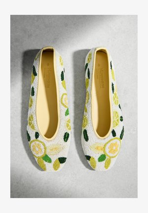 Pár béžových balerín se žlutým a zeleným korálkovým vzorem plátků citronu a listů na šedém povrchu.