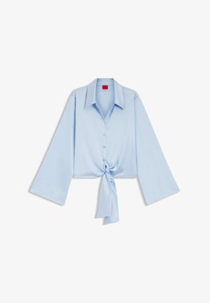 Light blue long-sleeve blouse with wide sleeves, button front, large collar, and a tied knot at the waist.