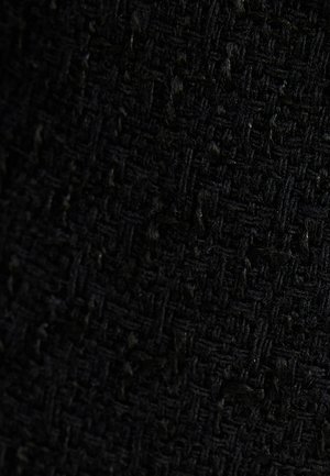 Tela negra texturizada con un patrón tejido, que muestra una mezcla de elementos de superficie lisos y peludos, creando profundidad e interés visual.