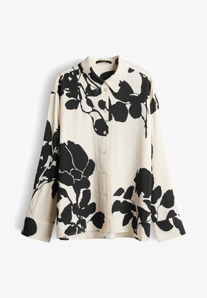 Roomwitte blouse met lange mouwen en knopen, bedrukt met grote zwarte bloemenprint en een spitse kraag, plat uitgestald tegen een witte achtergrond.