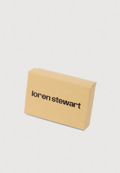 Barna kraft papír csomagolás téglalap alakú. Elülső oldalán a "loren stewart" szöveg található vastag fekete betűkkel. Egyszerű dizájn, nincsenek további minták.