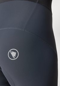Fekete kompressziós leggings sima textúrával, logó részlettel és lapos varrásokkal a kényelemért. Fő vizuális jellemzője a matt felület.