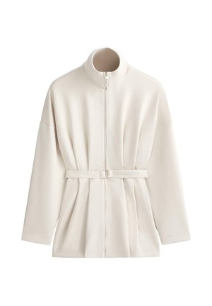 Jachetă cu mânecă lungă, culoare crem, cu guler înalt, fermoar frontal și curea reglabilă în talie, afișată pe fundal alb.