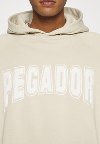 Pegador Jersey con capucha - beige
