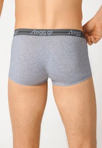 Boxer in cotone grigio con elastico nero in vita che presenta il nome del marchio "sloggi" in testo grigio chiaro. Texture liscia e design aderente.