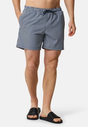 Marineblauwe en witte gestreepte zwembroek met een elastische tailleband, trekkoord en een zijzak. Draag met zwarte slippers.
