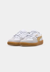 White and beige low-top Puma Palermo sneakers with gum soles, suede details, and lace-up closure, shown from the front on a white background.