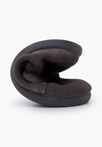 Pantofola in suede nera, forma curva con una texture morbida, dotata di suola in gomma e cuciture a mano, progettata per comfort e flessibilità.