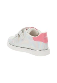 Zapatilla holográfica plateada con acento en el talón rosa, correas de Velcro, suela blanca y textura suave. Presenta un aspecto metálico y detalles en contraste.