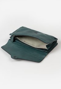 Teal leren portemonnee met een ritsvak en knoopsluiting. Het interieur heeft een gestreepte stofvoering. Compact rechthoekig ontwerp.