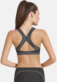 Schwarzer Sport-Braut mit strukturiertem Design, im Racerback-Stil und Hakenverschluss im Rücken. Verfügt über Kontrastnähte und glattes Material.