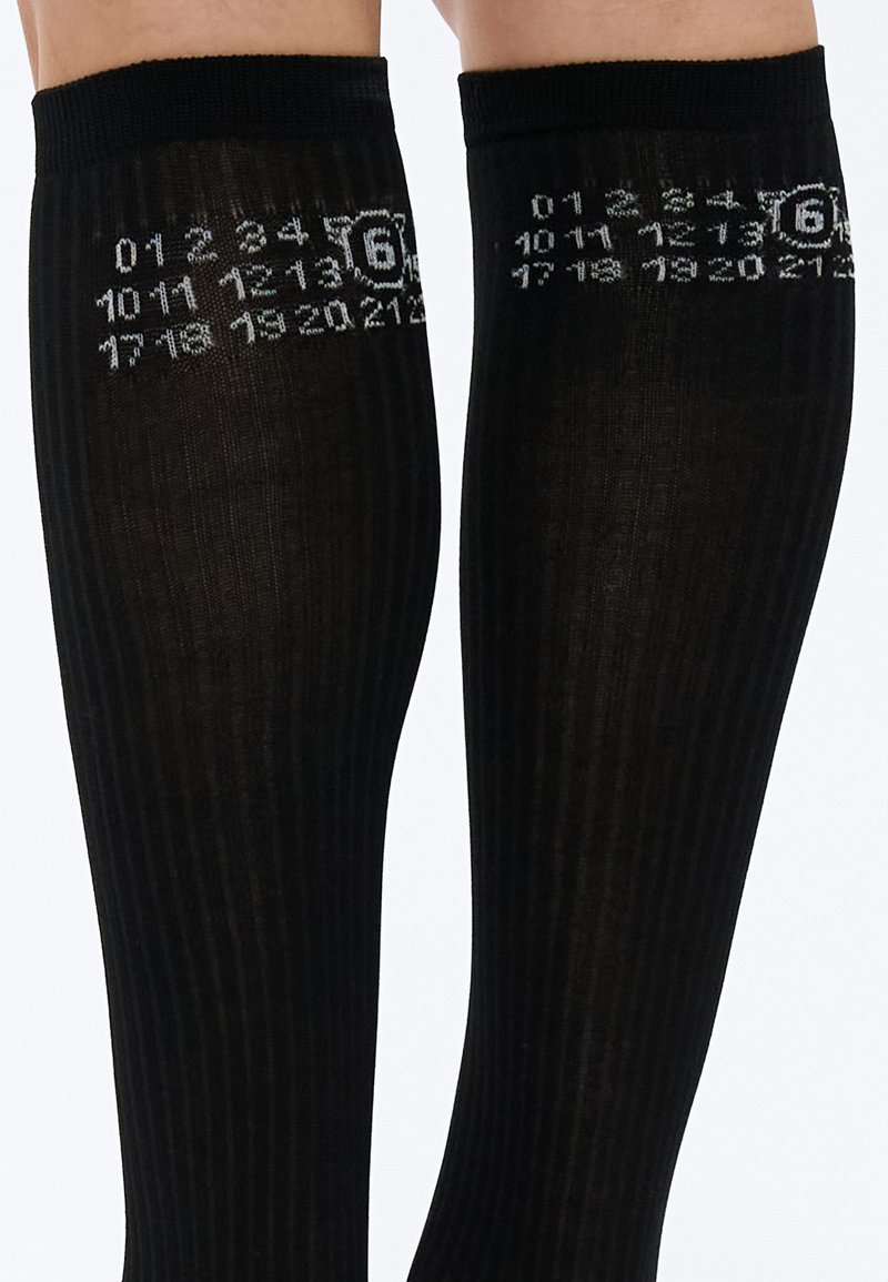 Black knee-high socks with ribbed texture, featuring a numeric pattern in gray and a circular graphic element on the side.