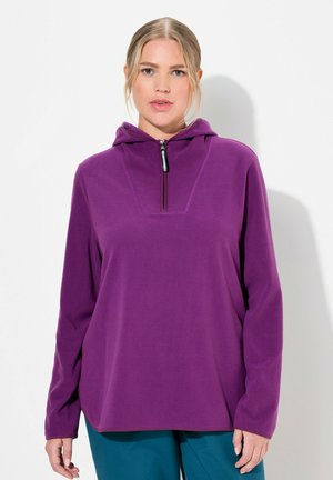 Fialový fleecový svetr s vyšším límcem a polo zipem. Dlouhé rukávy, volný střih, hladká textura a jednoduchý design.