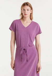 Vestido corto de manga corta en color púrpura con escote en V y cintura con cordón. Fabricado en tejido suave, presenta un corte relajado y una textura lisa.