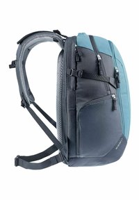Mochila con un diseño elegante y ergonómico; presenta una combinación de tela negra y turquesa, múltiples compartimentos con cremallera, correas acolchadas de malla y hebillas ajustables.