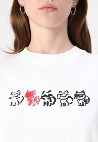 Balta sportinė palaidinė su penkiomis juodomis ir raudonomis katinų iliustracijomis. Katinai rodo įvairias ekspresijas ir detales, įskaitant saulės akinius.