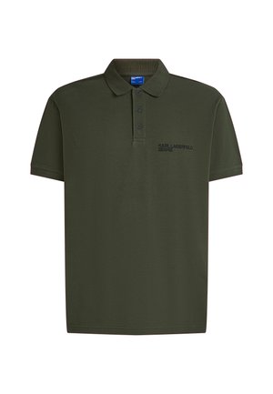 Olive zöld pólóing sima pamutból készült. Klasszikus gallérral, három gombbal és egy kis hímzett logóval rendelkezik a mellen.