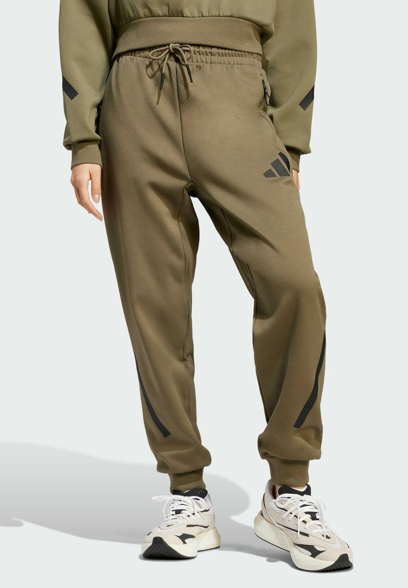 Olivové športové tepláky s elastickým pásom, šnúrkou na stiahnutie, bočnými vreckami a čiernymi akcentmi pozdĺž nohavíc.