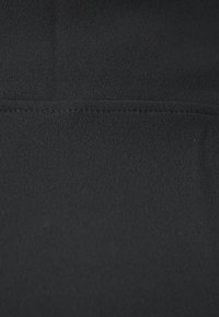 Schwarzer Stoff mit einer glatten, matten Textur, der eine gerade Nahtdetails an der Oberseite aufweist und eine durchgehend uniforme Oberfläche hat.