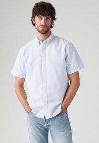 Korte mouwen, knoopsluiting shirt in lichtblauw met witte strepen, gemaakt van katoen. Heeft een opstaande kraag en een relaxte pasvorm.