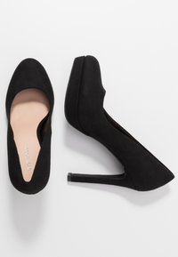 Escarpins en daim noir à talons hauts avec un bout pointu et une silhouette élégante. Dotés d'une doublure intérieure lisse et d'un talon bloc fin.