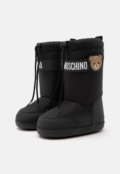 Ζευγάρι μαύρων χειμερινών μπότες Moschino με κλείσιμο με κορδόνια και λογότυπο αρκουδάκι στο πλάι.