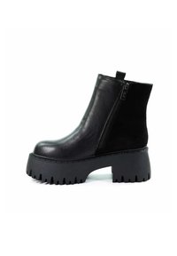 Czarne botki do kostki wykonane z gładkiej skóry i zamszu, z masywną, ząbkowaną podeszwą i bocznym zamkiem błyskawicznym. Posiadają pętelkę do łatwego zakładania.